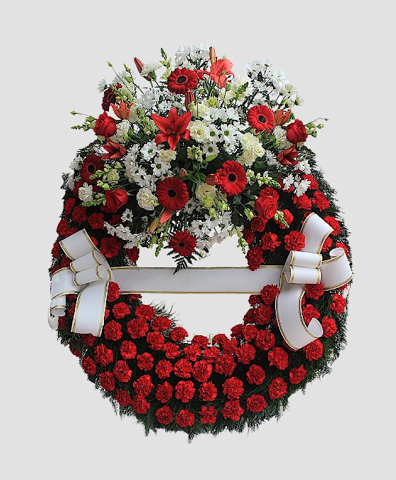 Corona funeraria con aro de claveles rojos y cabezal superior con flores blancas y rojas